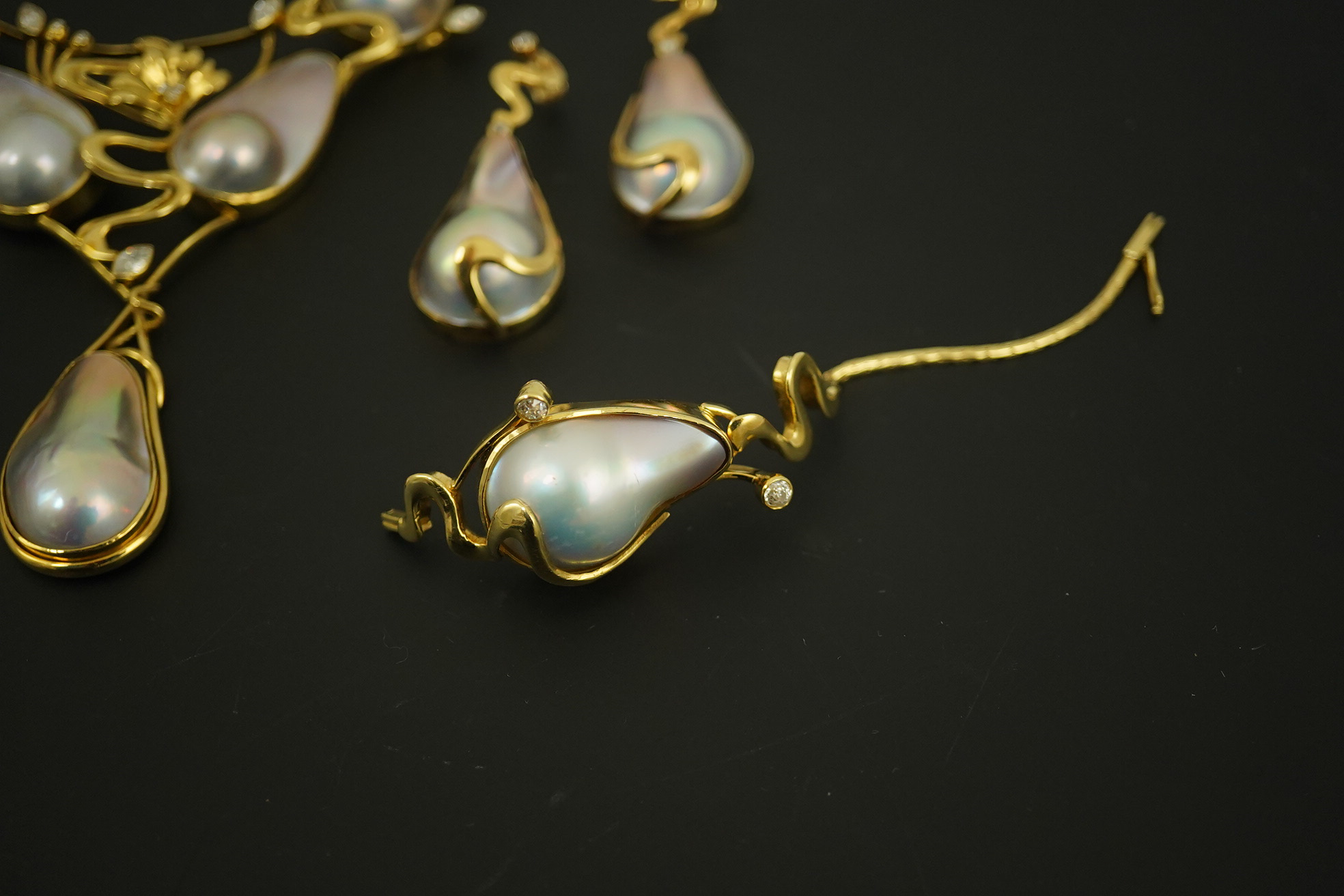 A modern suite of 18k gold, baroque pear, round and marquise diamond set jewellery